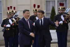 6日、中国の習近平国家主席（左）を出迎えるフランスのマクロン大統領＝パリ（AP＝共同）