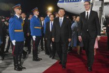 7日、セルビアの首都ベオグラードの空港に到着しブチッチ大統領（右）の歓迎を受ける中国の習近平国家主席（セルビア大統領府提供、AP＝共同）