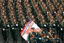 9日、ロシア・モスクワで行われた対ドイツ戦勝記念日の軍事パレードで行進する兵士（タス＝共同）