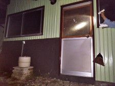 強盗に割られたため板を張って応急処置したドアの窓＝10日午後、群馬県安中市