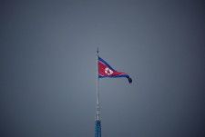 南北軍事境界線の北側にある北朝鮮の「宣伝村」に掲げられた国旗。韓国側から撮影された＝2022年7月（ロイター＝共同）