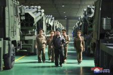 国防工業企業所で、改良された240ミリ口径の放射砲を搭載した車両を視察する北朝鮮の金正恩朝鮮労働党総書記（中央）（朝鮮中央通信＝共同）