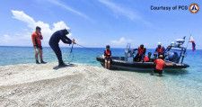 4月中旬、南シナ海のサビナ礁で投棄された破砕サンゴを調べるフィリピン沿岸警備隊員ら（フィリピン沿岸警備隊提供・共同）