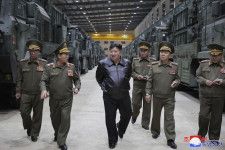 軍部隊に配備される新しい兵器の生産状況を確認する北朝鮮の金正恩朝鮮労働党総書記（左から3人目）＝14日（朝鮮中央通信＝共同）