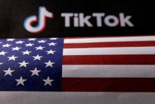 米国旗とTikTokのロゴ＝2023年6月（ロイター＝共同）