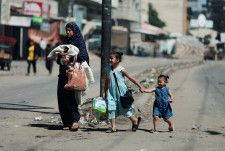15日、パレスチナ自治区ガザ最南部ラファから避難する住民ら（ロイター＝共同）