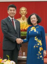 昨年8月、ベトナムの首都ハノイで立憲民主党の泉代表（左）と握手するチュオン・ティ・マイ氏（共同）