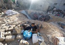 8日、ガザ地区南部ラファで、イスラエル軍の攻撃を受けた建物の跡を調べる住民（ロイター＝共同）