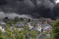 17日、ウクライナ東部ハリコフ市で、ロシアによる攻撃後に立ち上る煙（ゲッティ＝共同）