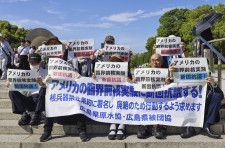 米国の臨界前核実験に抗議し座り込みを行う参加者＝18日午後、広島市の平和記念公園