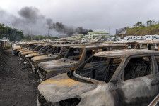 暴動で燃やされた車両＝15日、ニューカレドニア・ヌメア（AP＝共同）