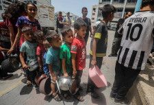 19日、パレスチナ自治区ガザ北部で食料配給の列に並ぶ住民ら（ゲッティ＝共同）