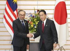 会談前にマレーシアのアンワル首相（左）と握手する岸田首相＝23日午後、首相官邸