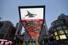 中国軍が台湾周辺で実施した軍事演習についてのニュースを映す北京市内の大型画面＝23日、北京（共同）