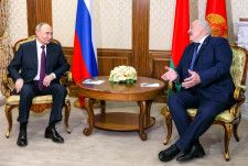 23日、ベラルーシのルカシェンコ大統領（右）と会談するロシアのプーチン大統領＝ミンスク（ロシア大統領府提供・タス＝共同）