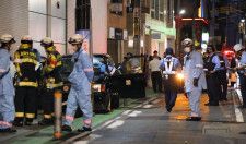 タクシーが歩行者をはねた現場に集まる救急隊員や警察官ら＝25日夜、福岡市中央区
