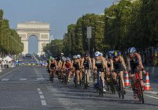 トライアスロン女子のパリ五輪テスト大会で、シャンゼリゼ通りをバイクで疾走する選手たち＝昨年8月、パリ（AP＝共同）