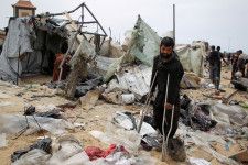 イスラエルの攻撃で被害を受けたテントを見つめる男性＝28日、ガザ地区ラファ（ロイター＝共同）