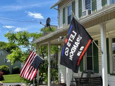 米ペンシルベニア州の住宅で上下逆さまに掲げられた米国旗（左）＝5月31日（ロイター＝共同）