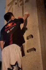 中国のSNS「小紅書」に投稿された、靖国神社の石柱に男がスプレーを吹き付ける動画の一場面（共同）