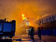ロシア軍の攻撃を受けたショッピングモールで消火活動に当たる消防士＝6日、ウクライナ南部ヘルソン州（ウクライナ非常事態当局提供、ロイター＝共同）