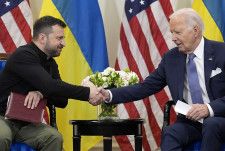 握手するバイデン米大統領（右）とウクライナのゼレンスキー大統領＝7日、パリ（AP＝共同）