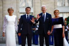 公式夕食会に出席するフランスのマクロン大統領（中央左）とバイデン米大統領（同右）＝8日、パリ（ロイター＝共同）
