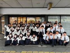 祇園町のチャレンジショップ「ココチャレ」で「C」を指で示してポーズを取る生徒と関係者