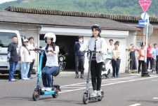 電動キックボード（右）や電動アシスト自転車（左）に試乗する参加者＝１８日午後、宮崎市清武町