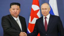 　１３日、ロシア極東アムール州のボストーチヌイ宇宙基地での首脳会談で握手するプーチン大統領（右）と北朝鮮の金正恩朝鮮労働党総書記（タス＝共同）