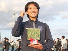 最優秀選手（MVP）の記念品を持って笑顔を見せる東洋大・西村真周