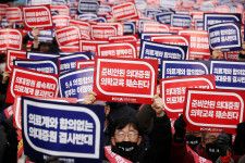 韓国の尹錫悦大統領は１日、医学部の定員増に反対する医師らとの対話に応じる姿勢を示す一方、政府案に反対する医師らが医師不足を解消するための合理的な代替案を提示していないと批判した。写真は抗議に参加する医師ら。３月、ソウルで撮影（２０２４年　ロイター/Kim Hong-Ji）