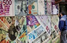 4月４日、世界の為替市場は「凪（なぎ）」の状態にあるが、各国中銀の利下げと１１月の米大統領選挙が動意付かせるとトレーダーや投資家はみている。写真は各国紙幣のイメージが掲示されたカイロの両替所。３月撮影（２０２４年　ロイター/Mohamed Abd El Ghany）