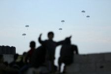４月１５日、米ホワイトハウス国家安全保障会議（ＮＳＣ）のカービー戦略広報調整官は、パレスチナ自治区ガザに搬入される人道支援物資がここ数日で大きく増えたと明らかにした。写真はガザ市で３月、米軍が上空から支援物資を投下する様子を見る人達（２０２４年　ロイター／Kosay Al Nemer）