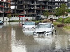 　４月１６日、アラブ首長国連邦（ＵＡＥ）で記録的な豪雨が発生し、少なくとも１人が死亡した。写真は冠水した道路を走る車。ドバイで撮影（２０２４年　ロイター/Abdel Hadi Ramahi）