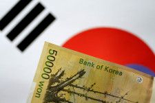 5月７日、    韓国銀行（中央銀行）が発表した４月末時点の外貨準備高は、前月末から５９億９０００万ドル減少して４１３２億６０００万ドルだった。写真はウォン紙幣と韓国旗のイメージ。２０１７年５月撮影（２０２４年　ロイター/Thomas White）