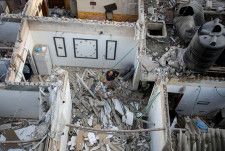 ５月７日、イスラエル軍は、パレスチナ自治区ガザ南部にあるラファ検問所のパレスチナ側を掌握し、特殊部隊が一帯を精査していると発表した。写真はラファで同日、イスラエルの空爆を受けた住宅の状況を調べる市民（２０２４年　ロイター／Hatem Khaled）