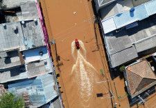 　ブラジル南部リオグランデドスル州の当局によると、先週から続く豪雨により発生した洪水で、５月７日までに９０人の死亡が確認され、１３１人以上と連絡が取れなくなっている。写真は冠水した道路を進む救命艇。同州のポルト・アレグレでドローン撮影（２０２４年　ロイター/Diego Vara）