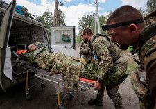 ロシアと国境を接するウクライナ北東部ハリコフ州を攻撃するロシア軍は、国境から約４キロのボウチャンスクの郊外で攻勢を強めている。ウクライナ軍が１２日明らかにした。写真はハリコフ州ボウチャンスク近郊で１２日、治療を受ける負傷したウクライナ兵（２０２４年　ロイター／Vyacheslav Madiyevskyy）