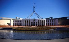 オーストラリア政府が１４日公表する年次予算では、好調な雇用市場とコモディティー（商品）価格の高騰を受け、２年度連続で財政黒字となる見通し。写真はオーストラリア連邦議会前を歩く観光客。キャンベラで１７年撮影。（2024年 ロイター/David Gray/File Photo）