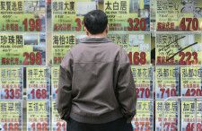 ムーディーズは１４日のリポートで、香港と中国本土で長引く不動産不況により、香港の銀行の信用力が弱まる可能性があると指摘した。写真は不動産屋の前で広告をみる男性。香港で０８年撮影。（2024年 ロイター/Bobby Yip  (CHINA)）