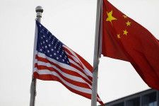 米国のバイデン政権が対中関税の大幅な引き上げを発表したが、中国政府の反応は比較的冷静だ。写真は米中の国旗。北京で２０２１年１月撮影（２０２４年　ロイター／Tingshu Wang）