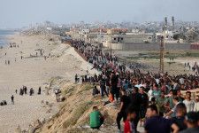 　５月２０日、米中央軍（ＣＥＮＴＣＯＭ）は、米国が設置した浮桟橋からパレスチナ自治区ガザにこれまで５６９トン以上の人道支援物資が搬入されたと明らかにした。写真はガザへの支援物資を求めて米国が建設した桟橋に集まるパレスチナの人々。ガザで１９日撮影（２０２４　ロイター／Ramadan Abed）
