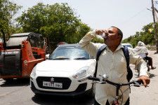 　６月３日、インドではこの夏の猛烈な熱波で１００人以上が死亡し、数万人が体調を壊した疑いがあることが、当局の発表や各種報道で明らかになっている。写真は熱波のなかで水を飲む男性。インドのニューデリーで５月撮影（２０２４　ロイター／Priyanshu Singh）