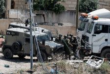 国連人権高等弁務官事務所（ＯＨＣＨＲ）は４日、パレスチナ自治区ガザでイスラエルとイスラム組織ハマスの戦闘が始まって以降、ヨルダン川西岸でイスラエル治安部隊とユダヤ人入植者がパレスチナ人５００人以上を殺害したとし、暴力の停止を訴えた。写真はパレスチナの男性を拘束するイスラエル兵。ヨルダン川西岸で５月撮影。（2024年 ロイター/Raneen Sawafta/File Photo）