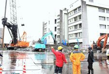 マンション建設地で掘削作業を行う作業員ら＝松江市殿町