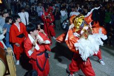 大勢の住民が見守る中、力強く麒麟獅子舞を演じる若者たち＝鳥取市賀露町北１丁目、賀露神社
