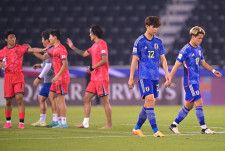 喜ぶ韓国の選手たちとは対照的に、がっくりと肩を落とす高井（22番）と松木（17番）。写真：金子拓弥（サッカーダイジェスト写真部／現地特派）