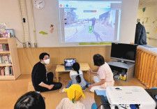 パソコンを操作してロボットを動かす女児（中央）。ロボットのカメラが撮影する映像が大型モニターに映し出されている＝千葉市の千葉大医学部付属病院で（ミルフィーユ小児がんフロンティアーズ提供）