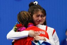 女子50ｍバタフライの表彰式直後、張雨霏（奥）と池江（手前）は涙の抱擁を交わした。(C) Getty Images
